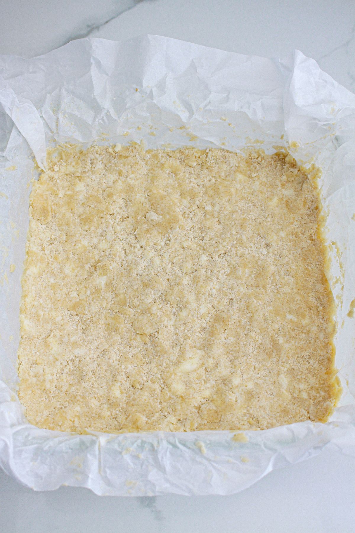 shortbread crust pressed into the bottom of a glass baking dish.