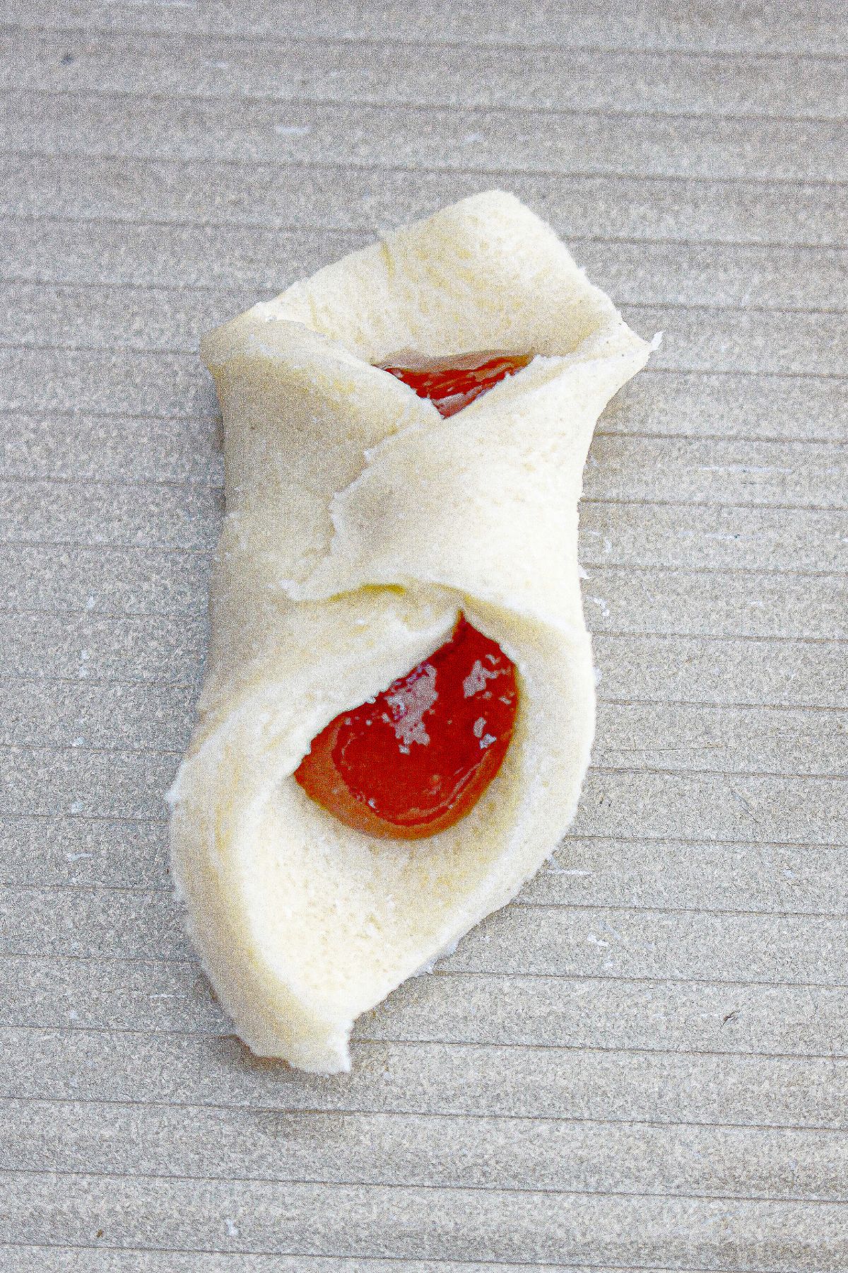 cookie dough being wrapped around jam.