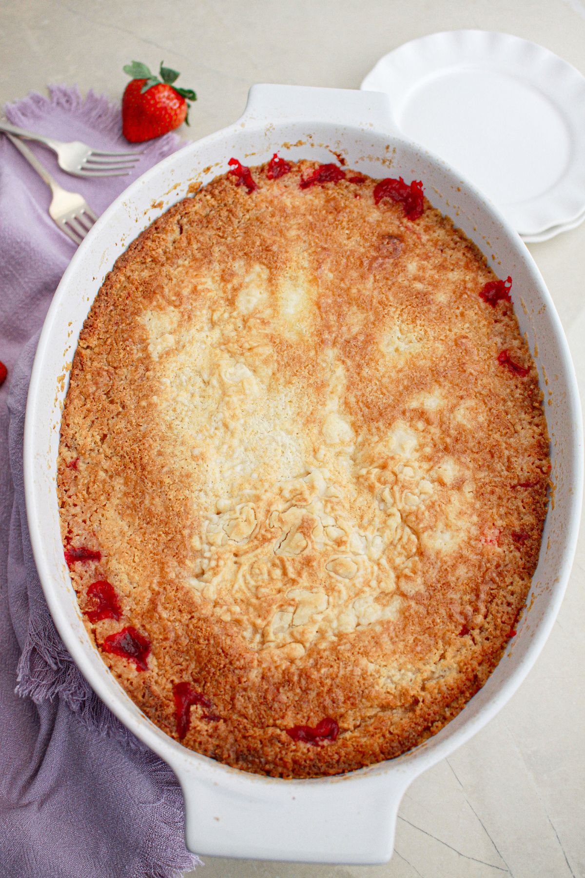 uncut strawberry dump cheesecake in a baking dish.