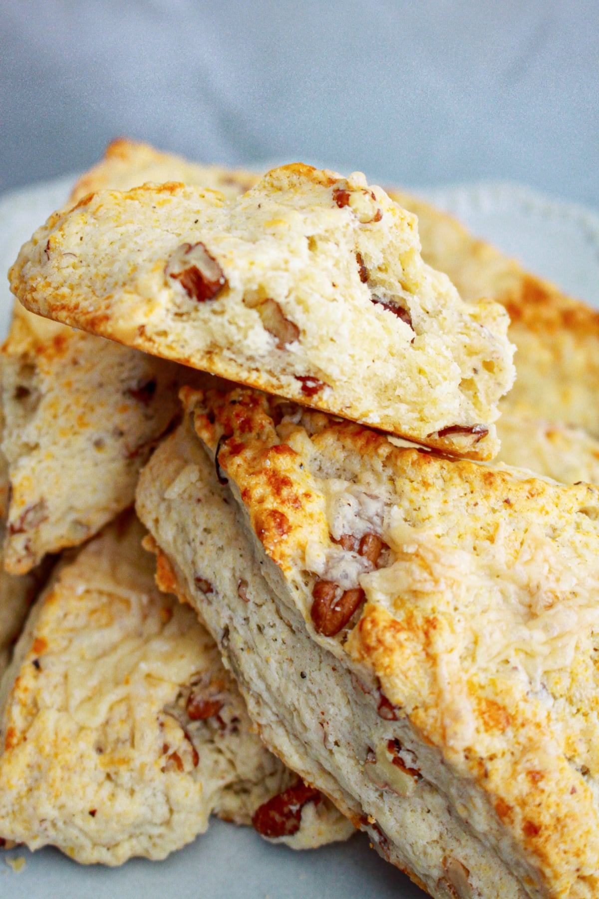 white cheddar scones stacked on a plate.