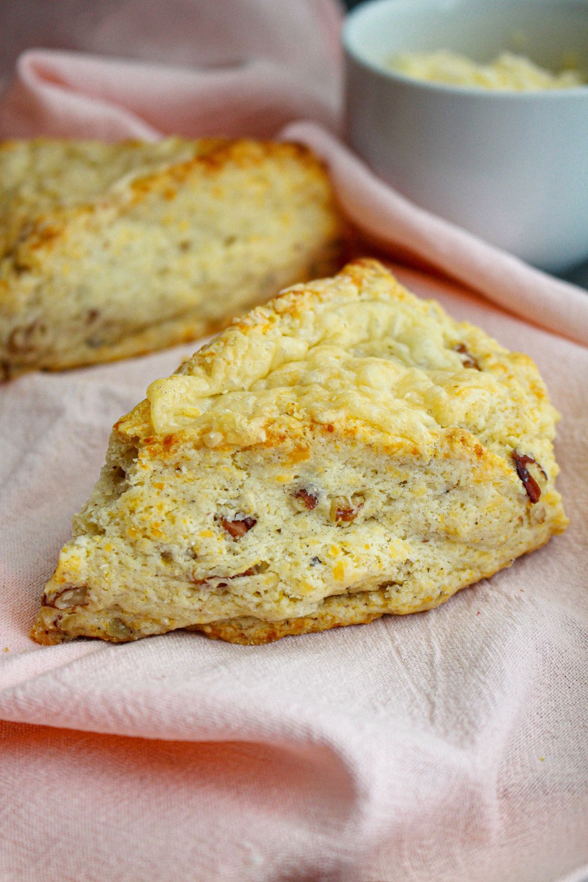 two white cheddar scones on a kitchen towel.