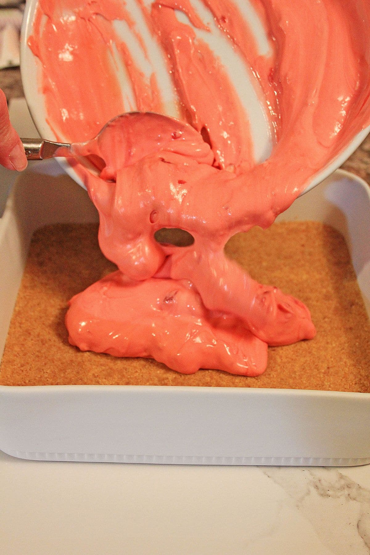 red layer being spread on top of the crust.