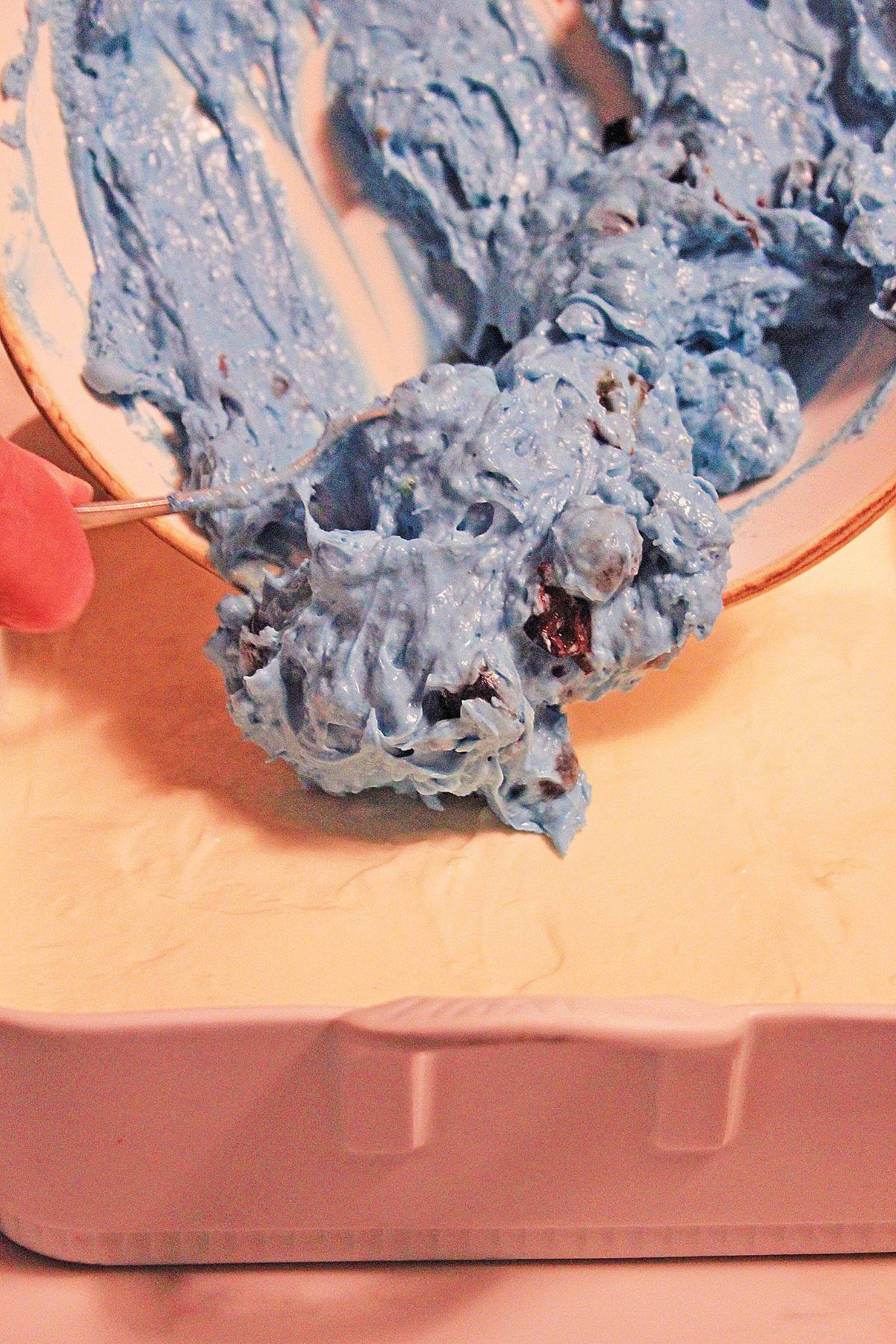 blue layer being added on top of the dessert.