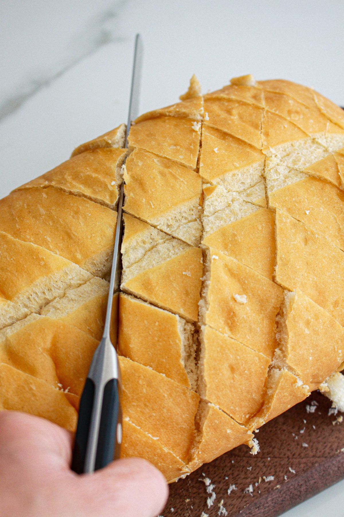 loaf of bread being sliced into triangles.