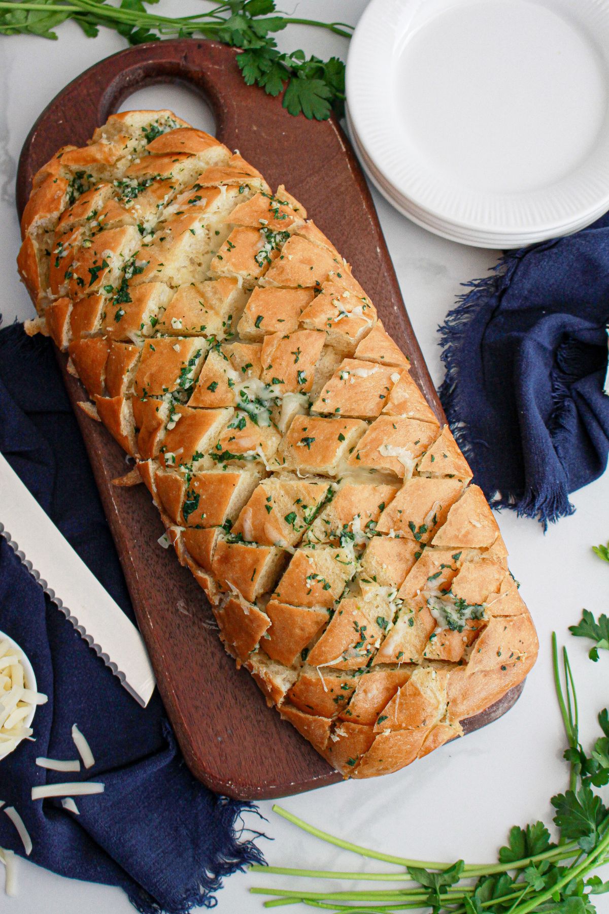 baked garlic bread on a wooden cutting board.