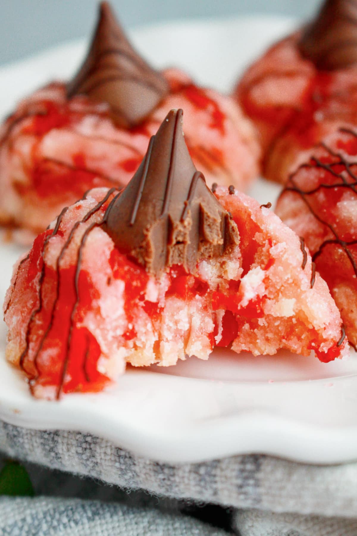 cherry blossom cookies with a bite missing on a plate.