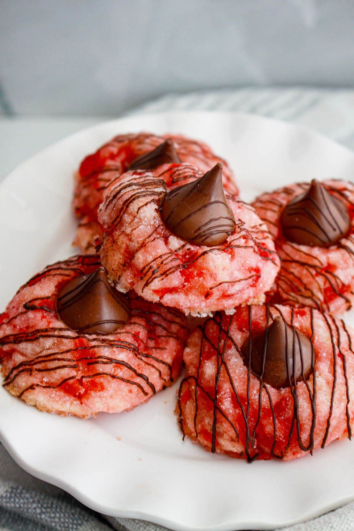 five cherry blossom cookies stacked on a plate.