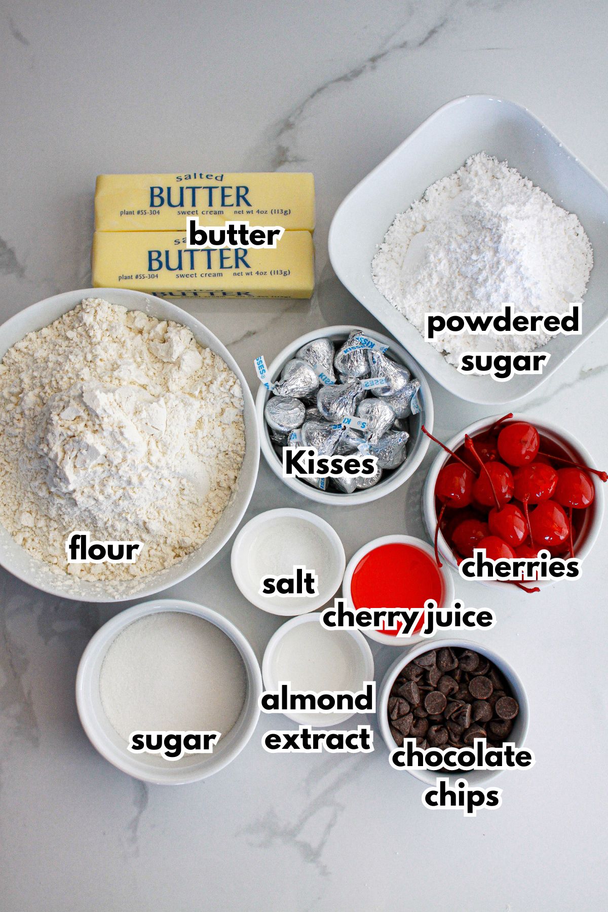 bowls of ingredients needed to make cherry blossom cookies on a marble counter.