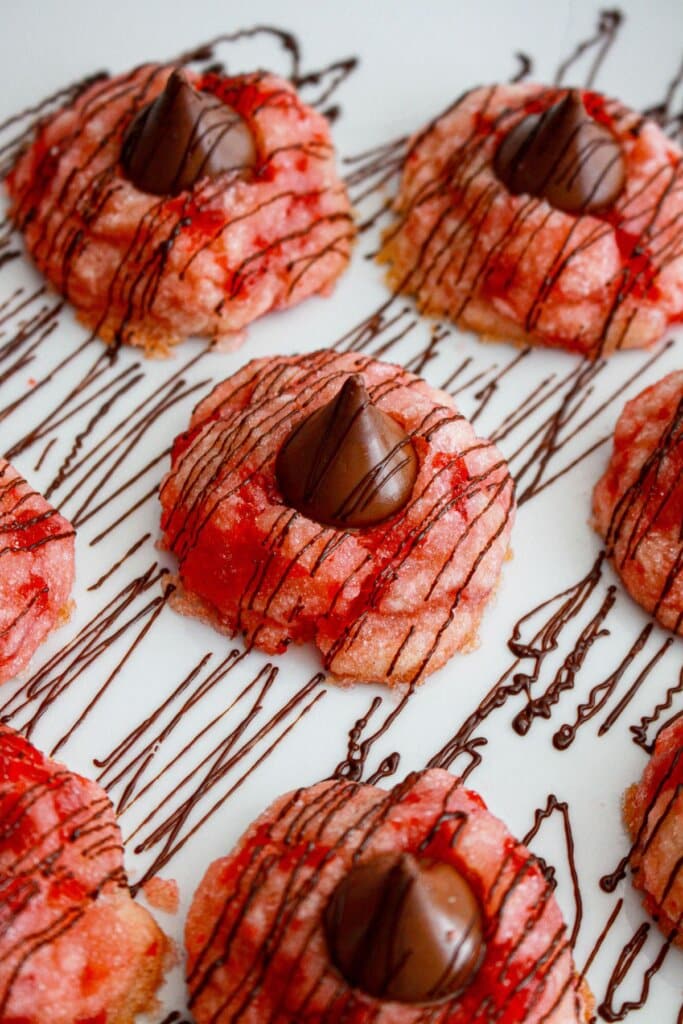 melted chocolate chips being drizzled over the top of cookies.