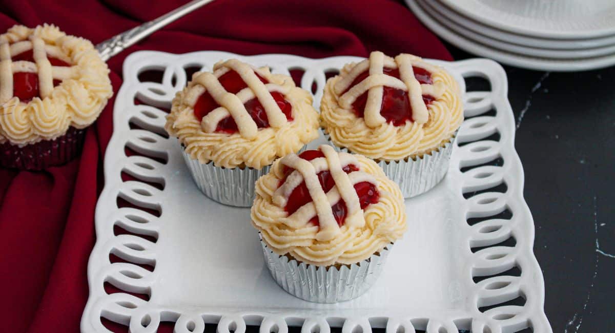 three cherry pie cupcakes on a white plate.