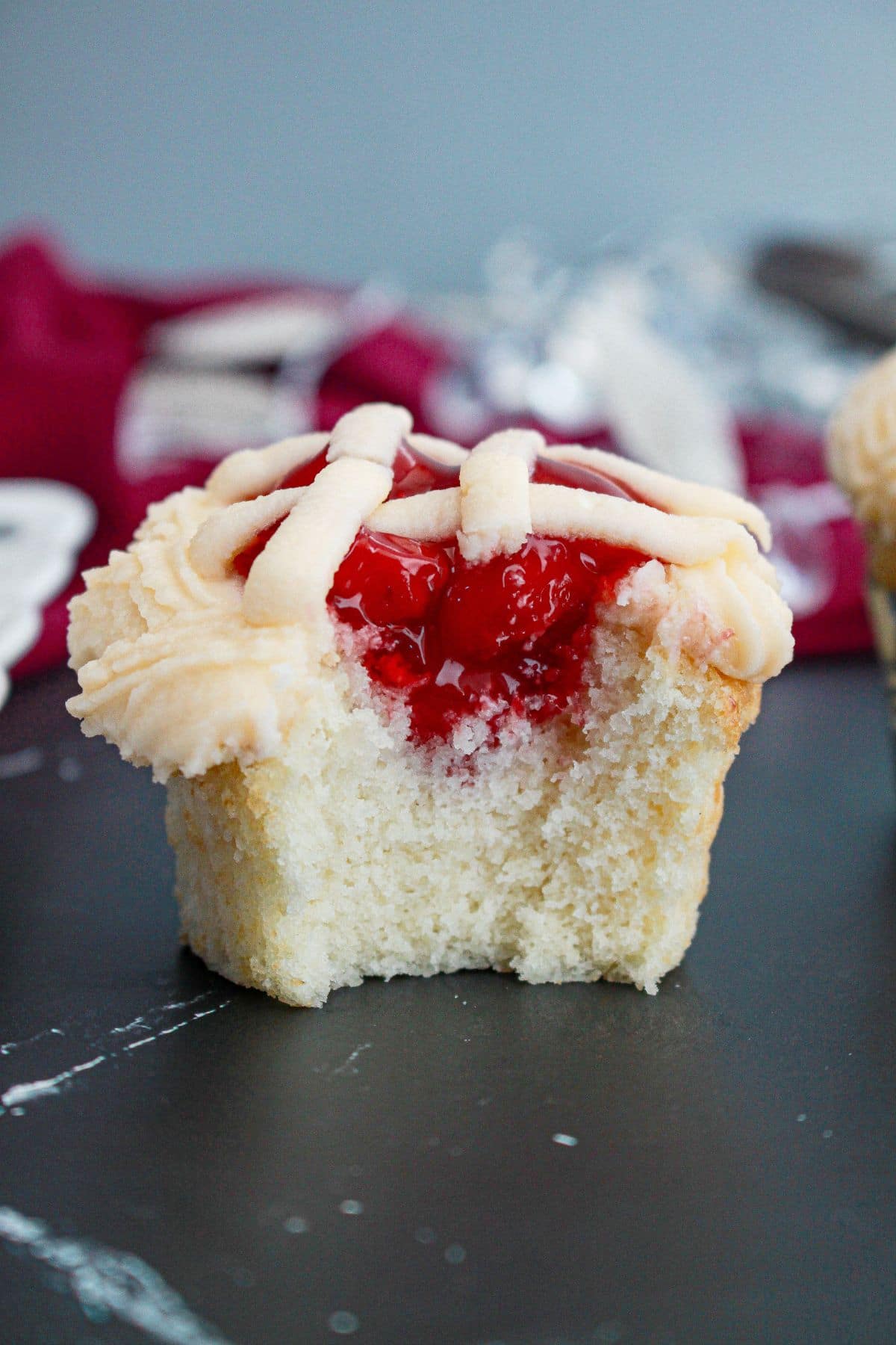 cherry pie cupcake being bitten in half.