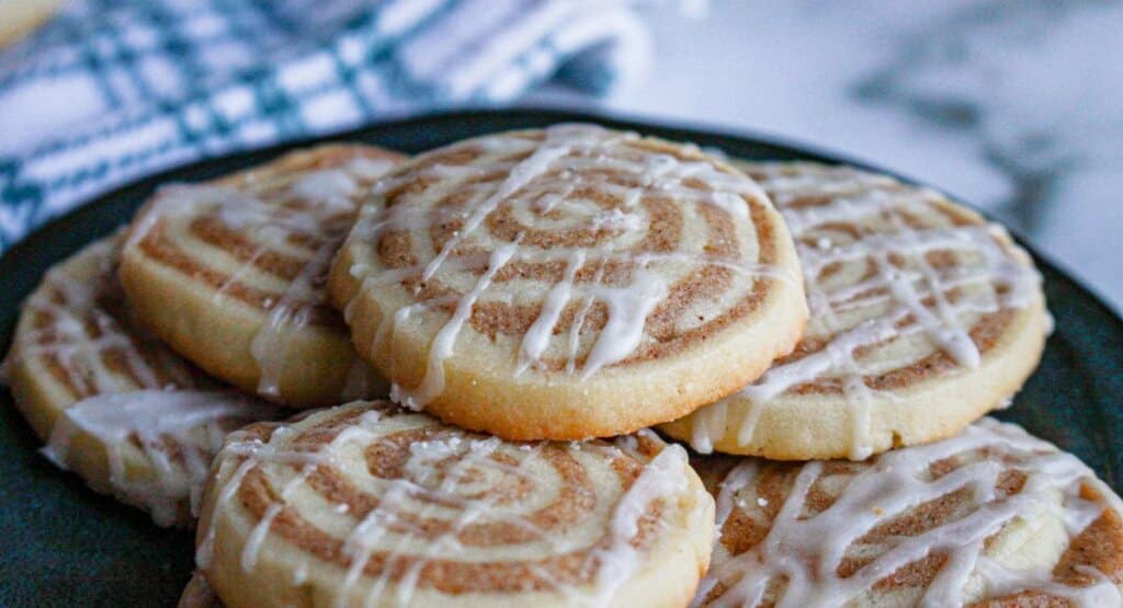 cinnamon bun cookies stacked on a plate.