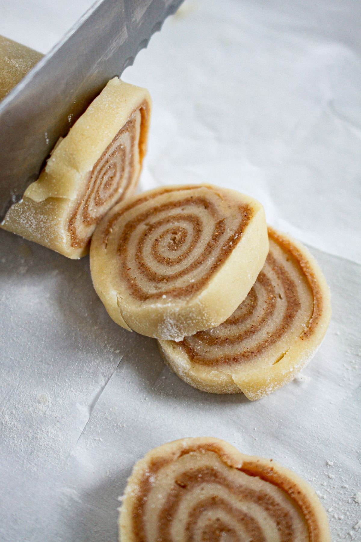 cookie dough being sliced into rounds.