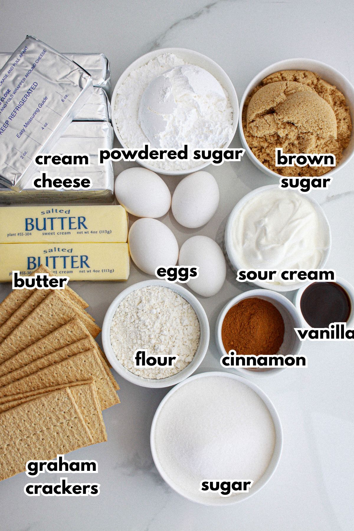 bowls of ingredients needed to make cinnamon roll cheesecake on a counter.