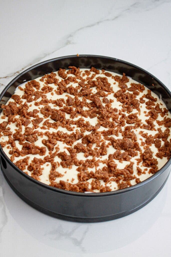 raw cinnamon roll cheesecake in a springform pan ready for the oven.