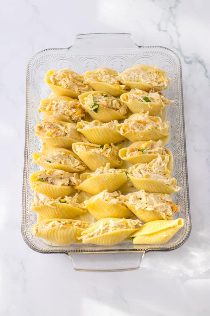 stuffed shells in a glass baking dish ready for the oven.