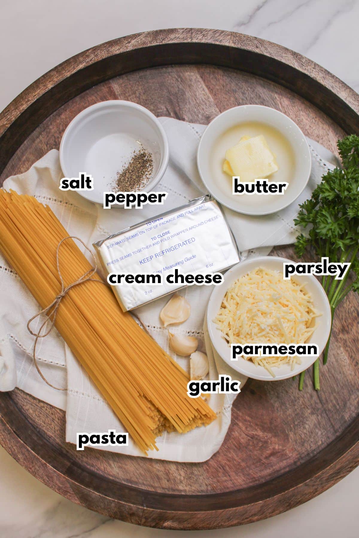 bowls of salt, pepper, butter, cream cheese, pasta, and parmesan cheese.
