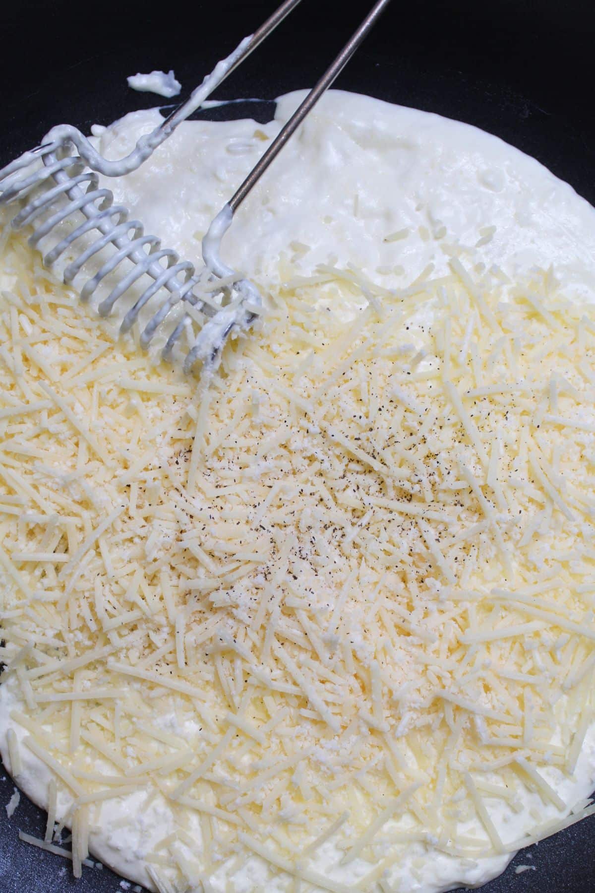 cream cheese sauce being made in a cast iron skillet