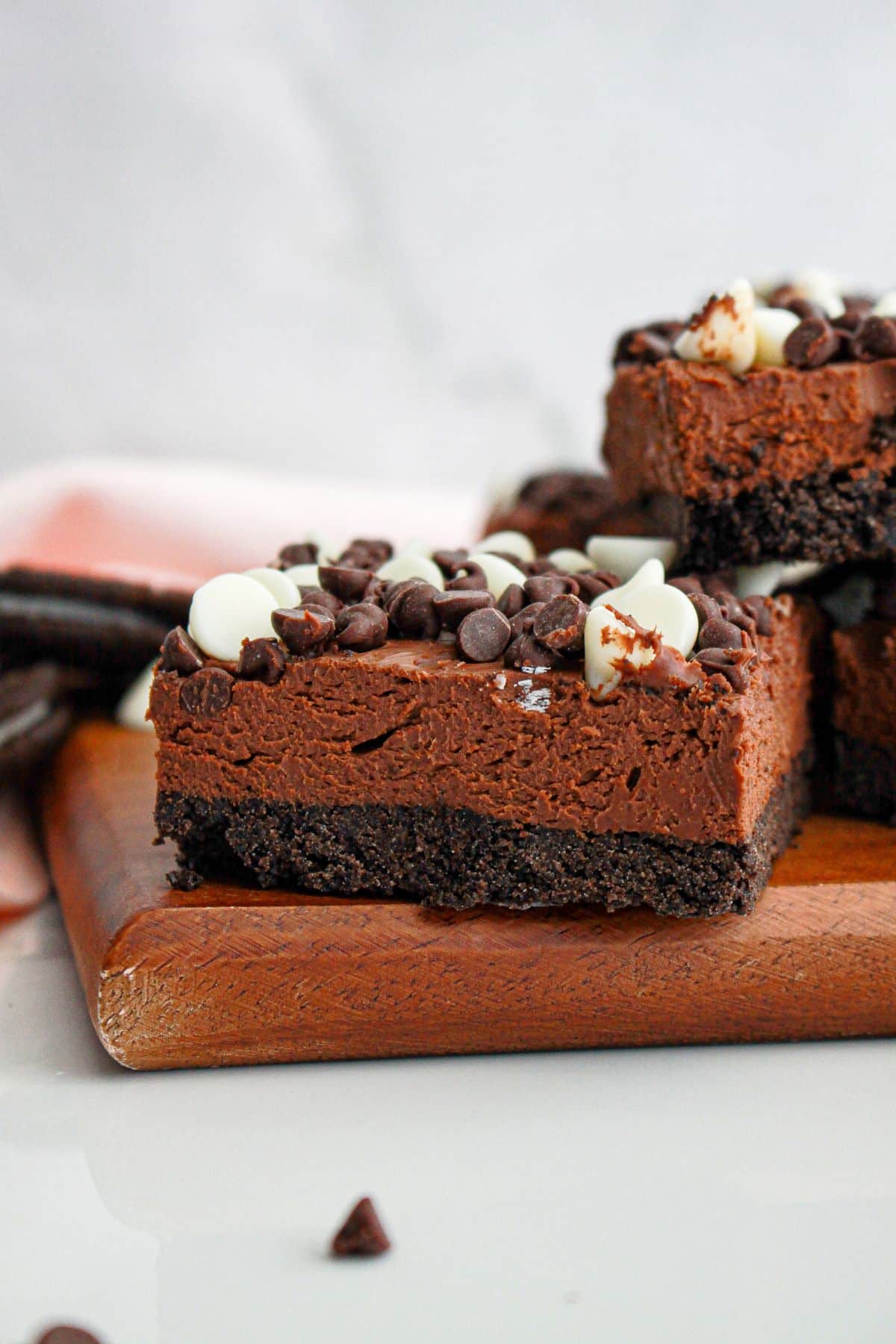 slice of death by chocolate cheesecake on a wooden cutting board.