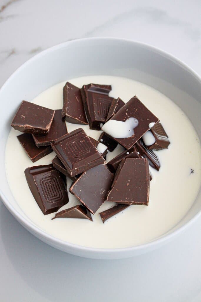 dark chocolate and heavy cream in a bowl ready for the microwave.