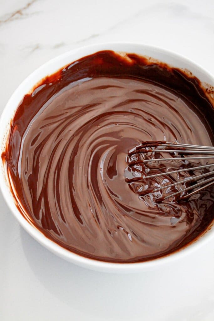 chocolate cheesecake batter being whisked in a large bowl