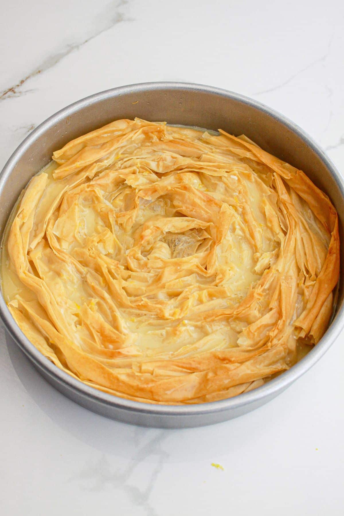 lemon crinkle cake baked in a round cake pan.