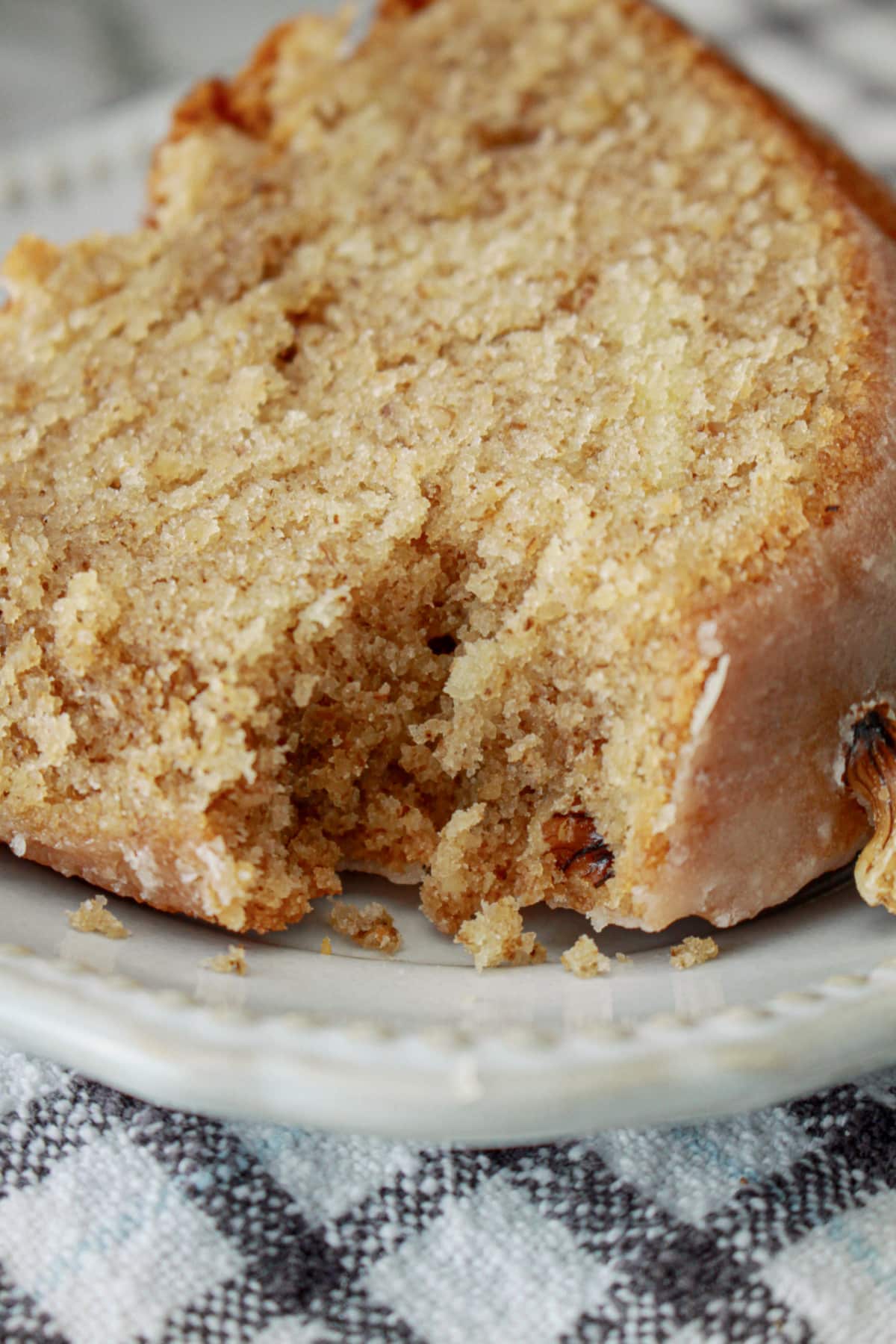 slice of maple pound cake on a small plate with a bite missing.