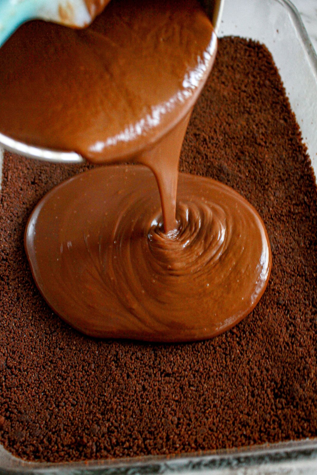chocolate layer being poured on top of the crust.