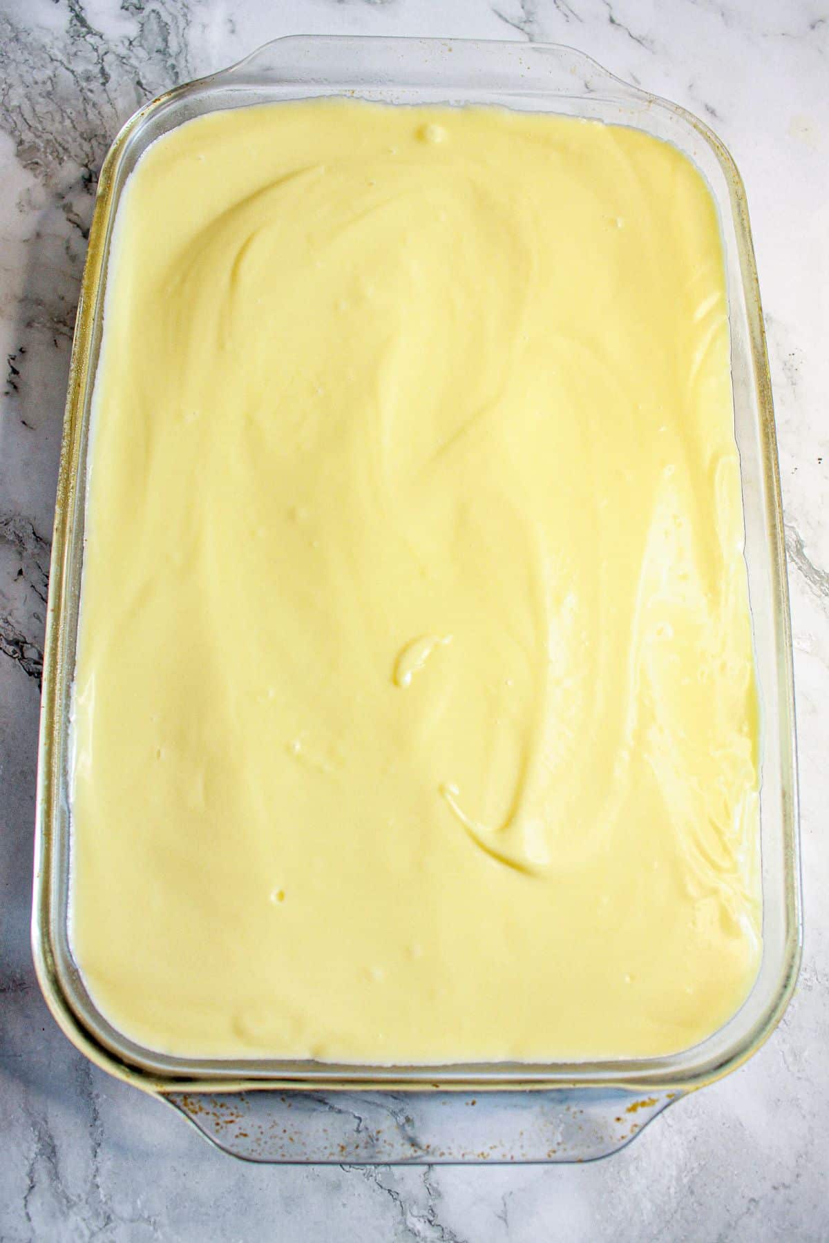 vanilla pudding layer in a glass baking dish.