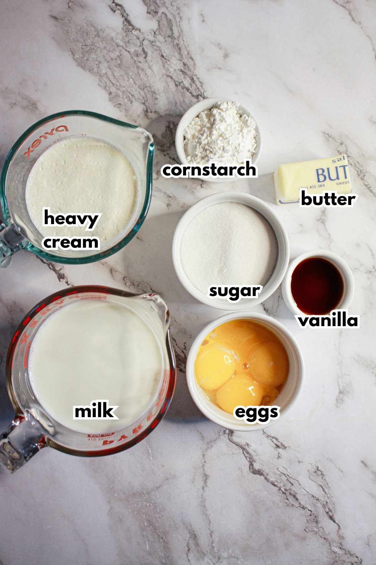 bowls of ingredients needed to make homemade vanilla pudding on a counter.