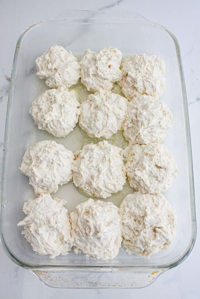 biscuit dough in a glass baking dish.