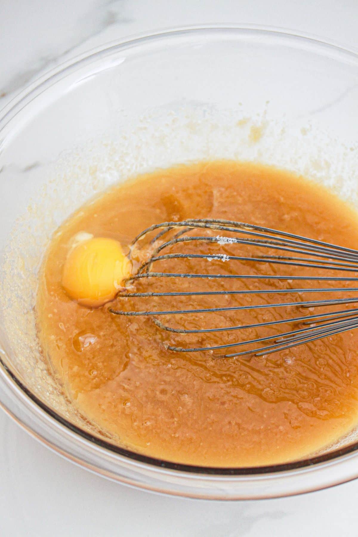 wet ingredients being mixed in a large mixing bowl.