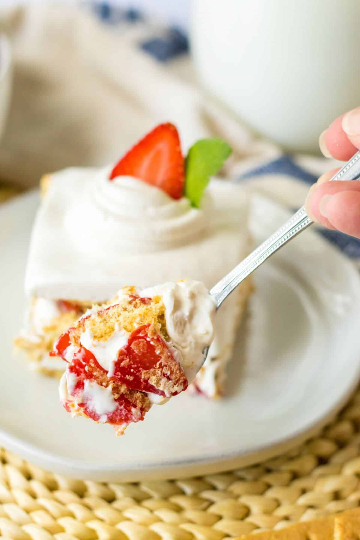 bite of strawberry icebox cake on a small plate.