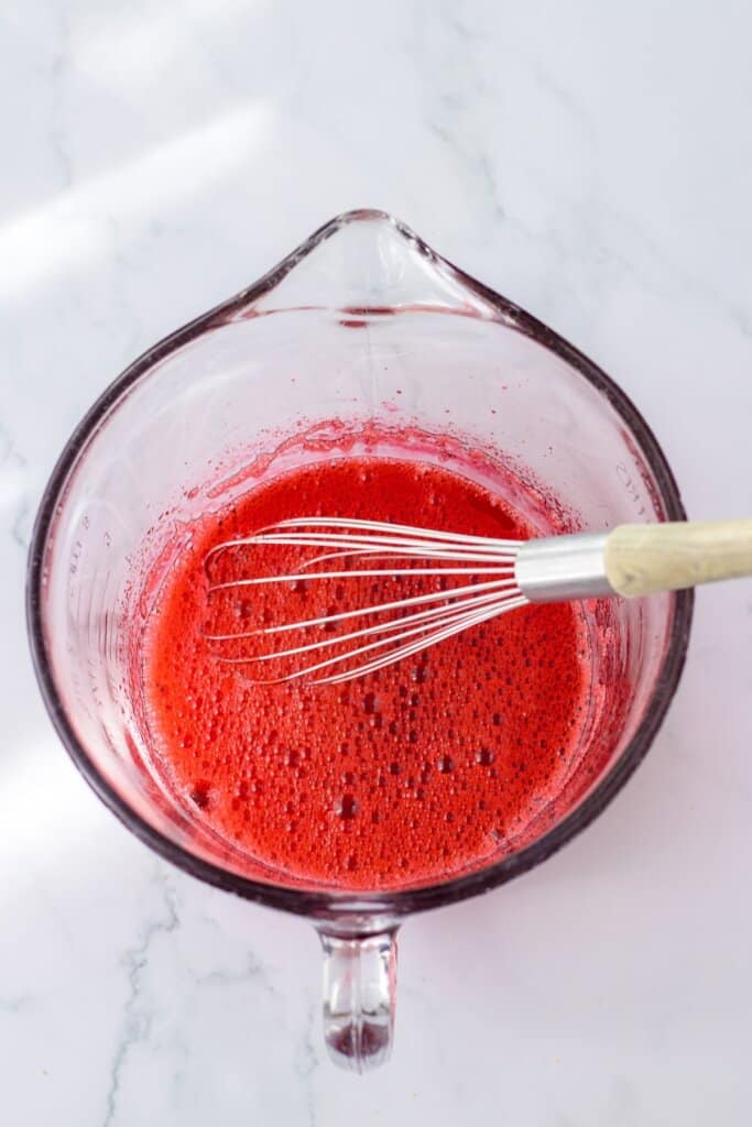 gelatin being mixed in a large measuring cup.