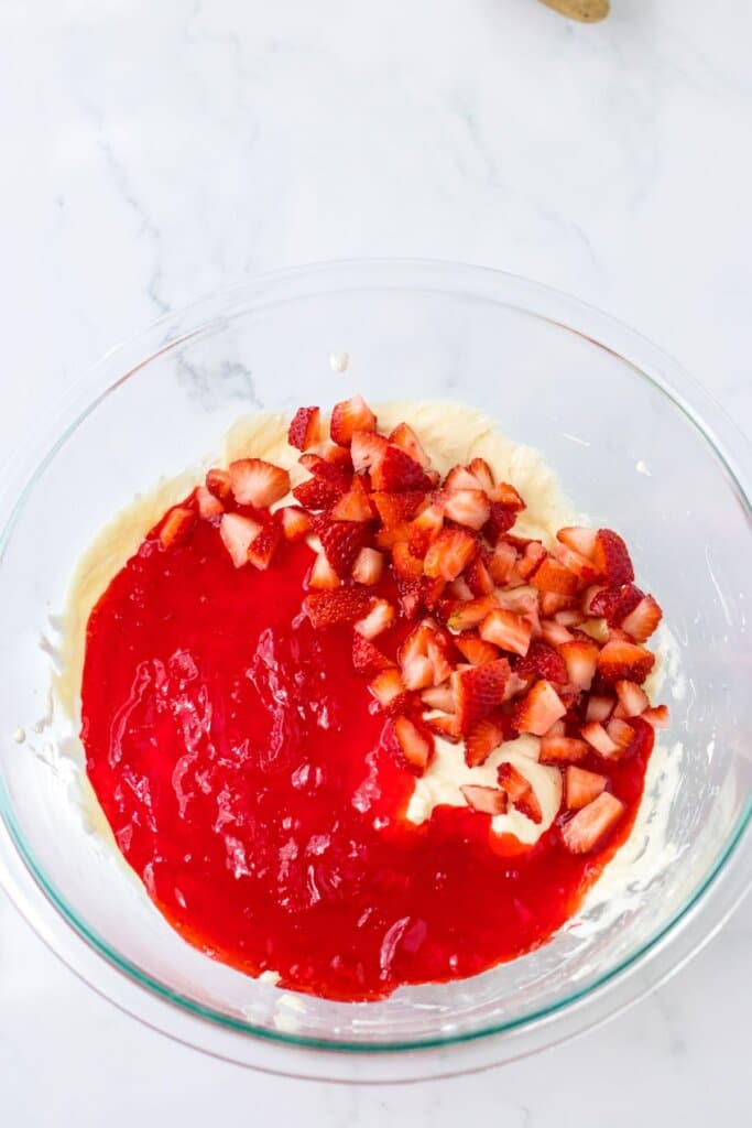 strawberries being added to cream cheese mixture.