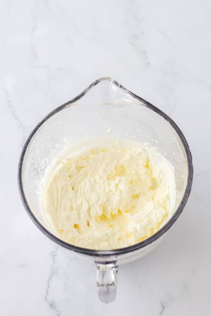 whipped cream being made in a mixing bowl.