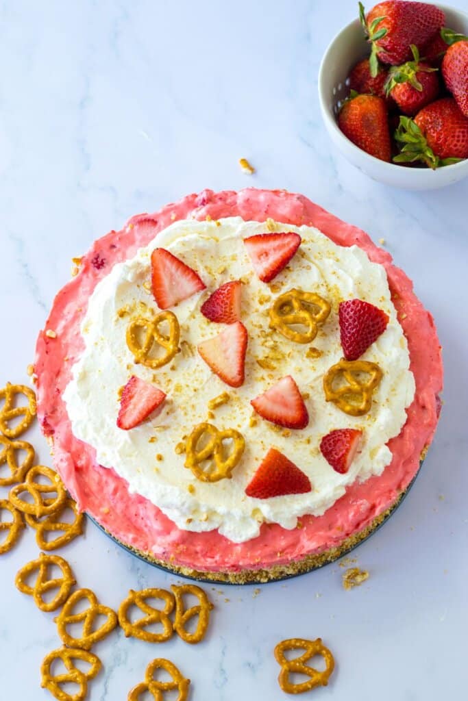 uncut strawberry pretzel pie on a table.