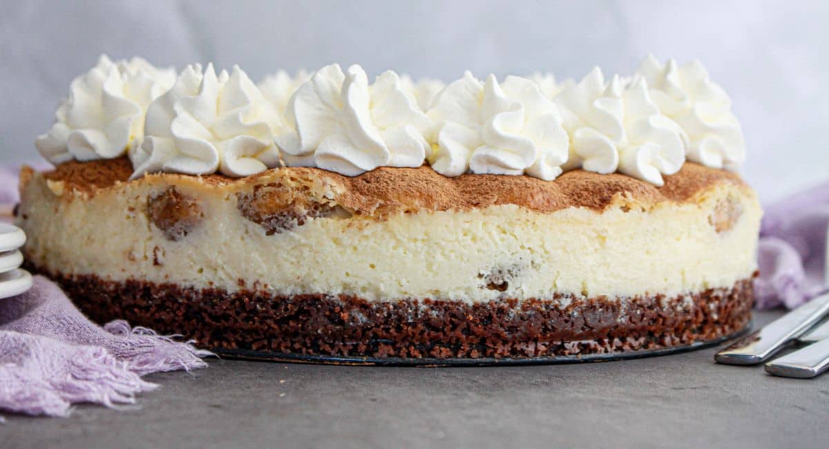 uncut tiramisu cheesecake on a counter.