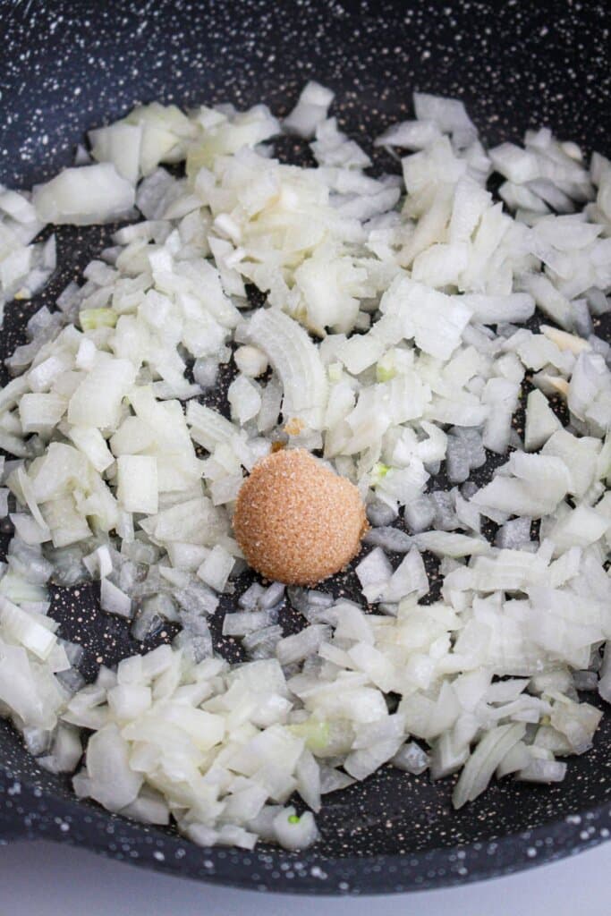 onions and brown sugar being cooked in a skillet.