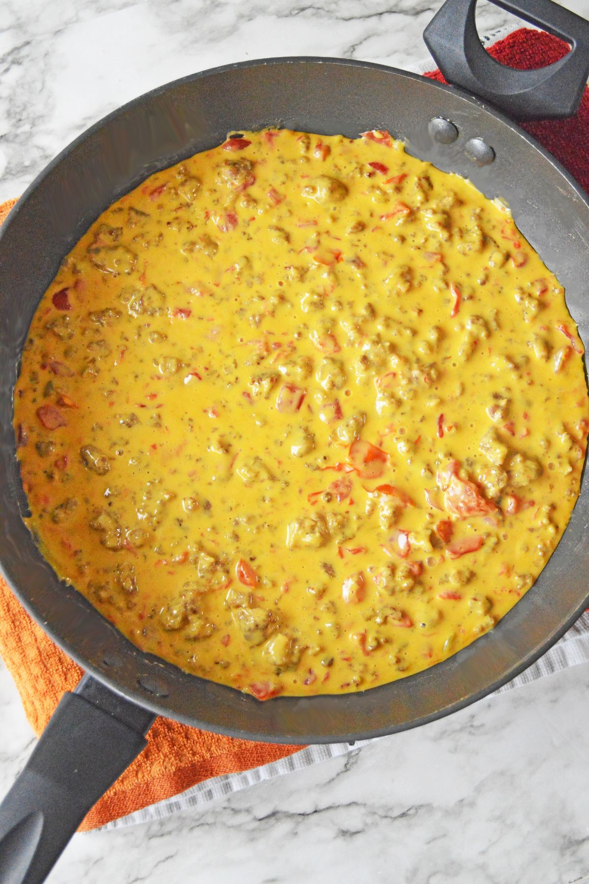 melted cheese, tomatoes, and sausage in a large skillet.