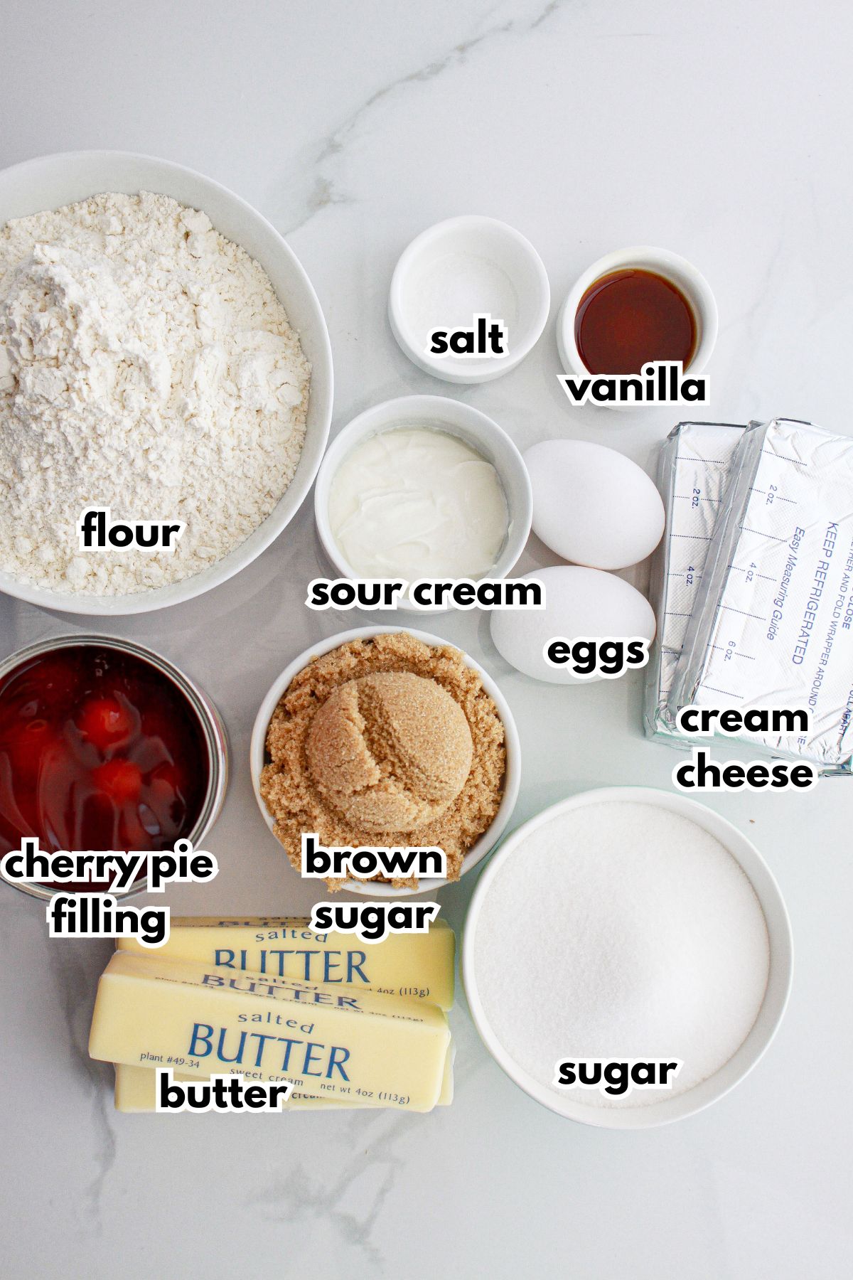 flour, sour cream, salt, vanilla, eggs, cream cheese, cherry pie filling, butter, brown sugar, sugar on the counter.