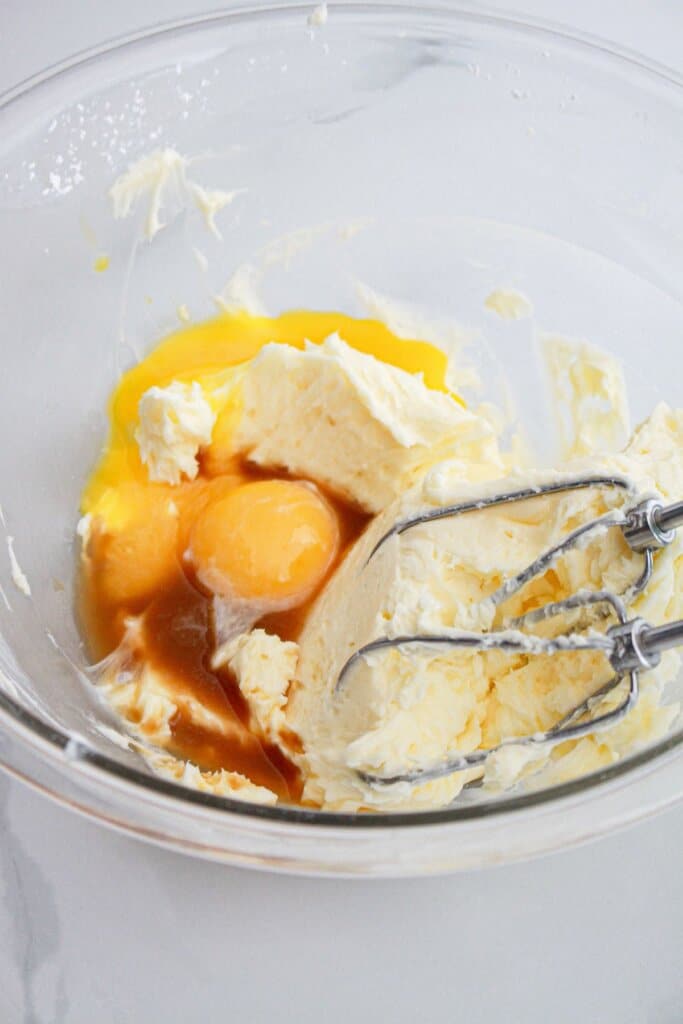 cookie dough being mixed in a large glass bowl.