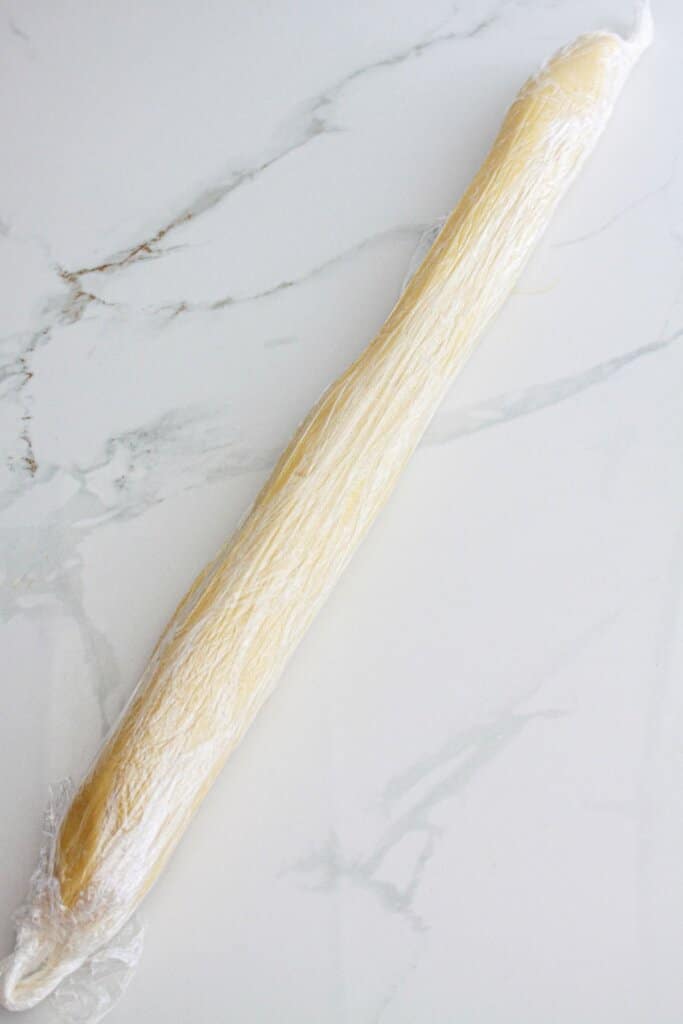 cookie dough shaped into a log and wrapped in plastic wrap.