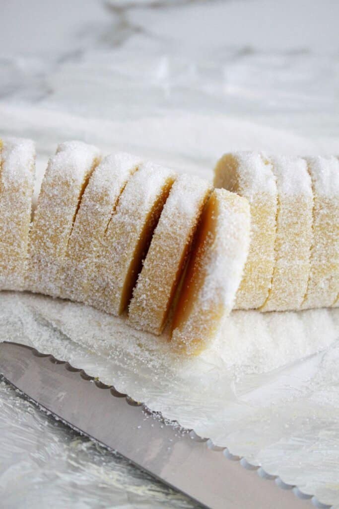 cookie dough being sliced with a knife.