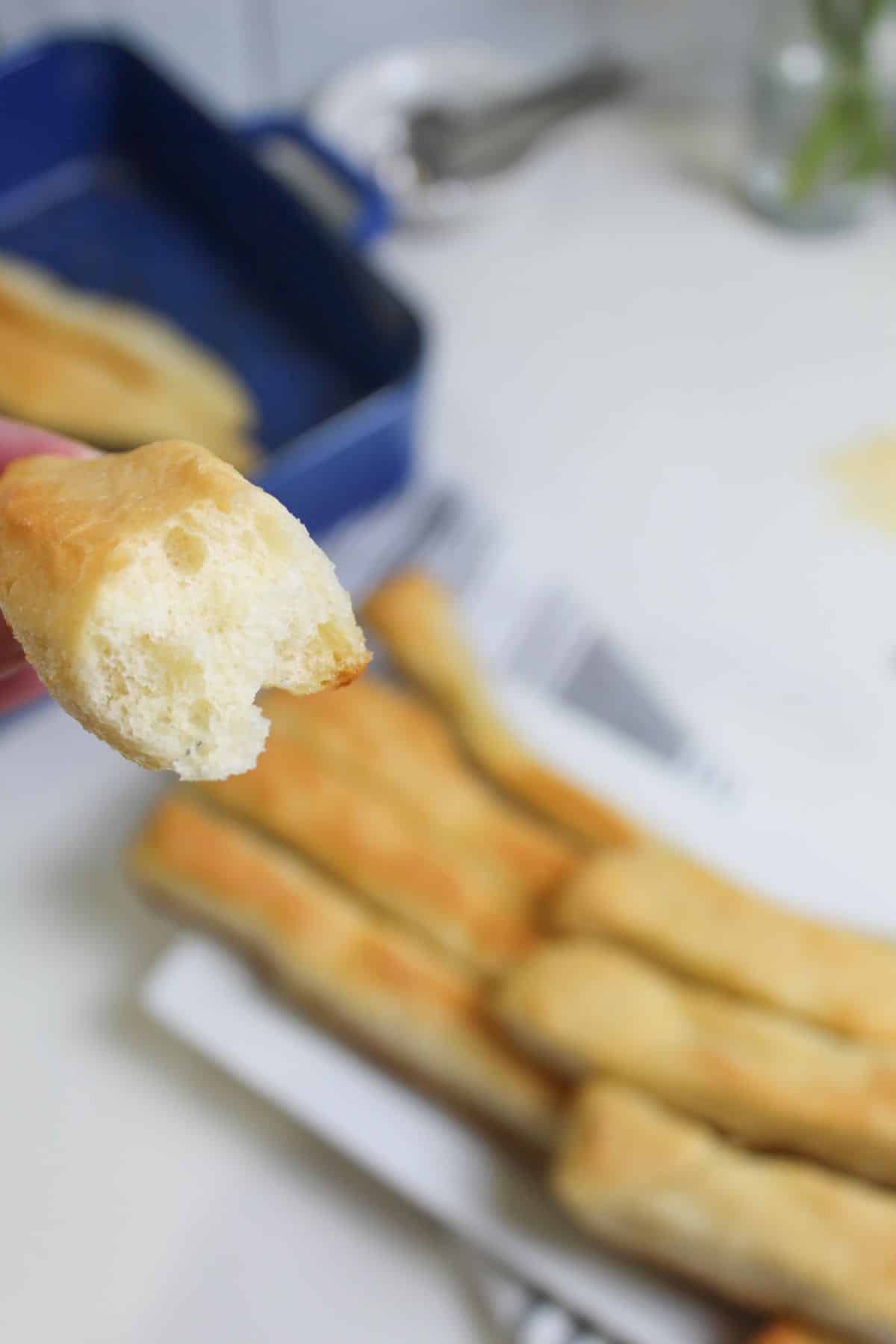 breadstick broken in half held in the air.