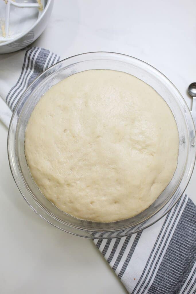 dough rising in a large glass bowl.