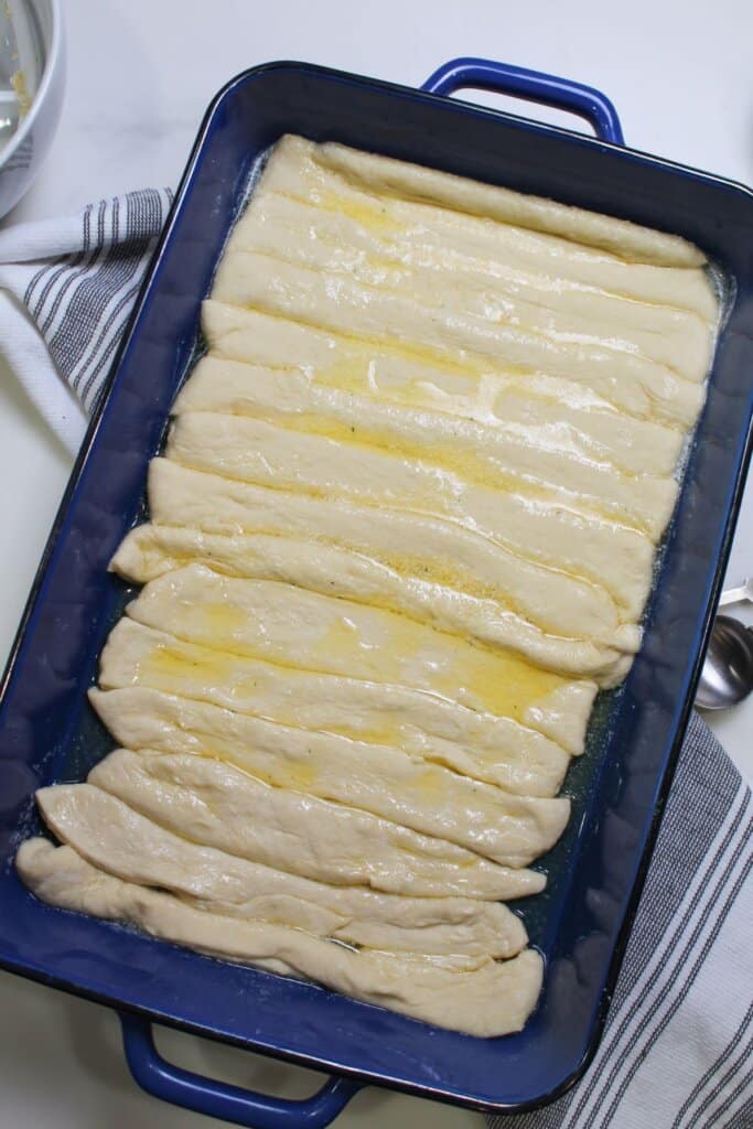 raw breadsticks in a baking dish ready for the oven.