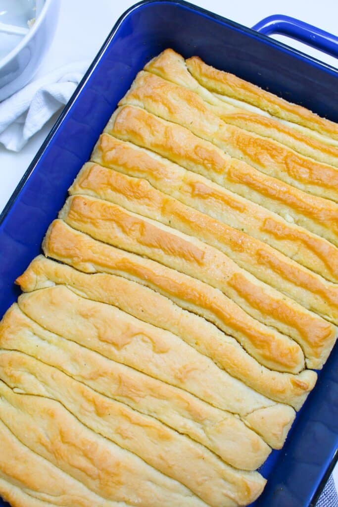 finished garlic breadsticks in a baking dish.