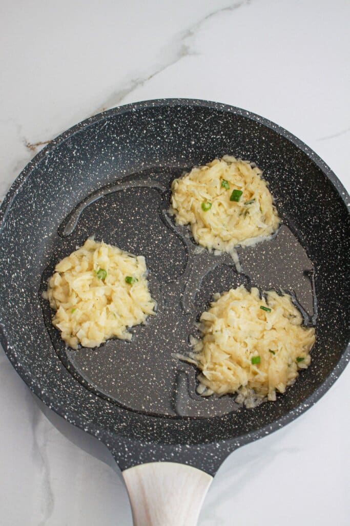 patties being cooked in a large skillet.