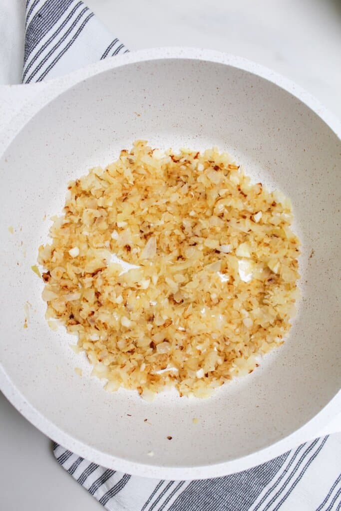 onions, garlic, and olive oil being sauted in a large pot.